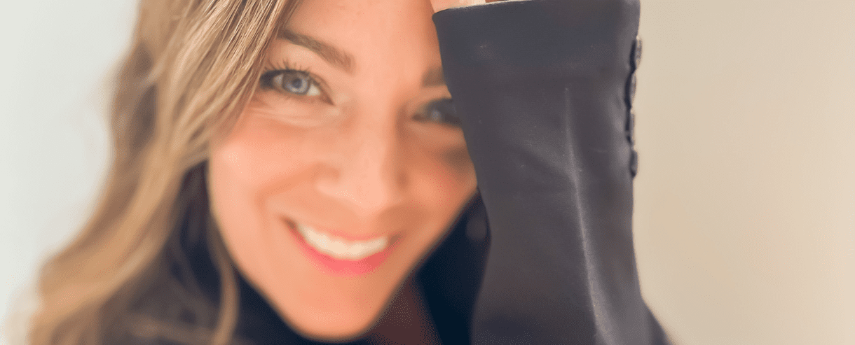 Person smiling at camera with arm held up